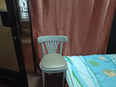 a white chair sitting next to a bed at Стаи на пъпа на Варна, входа на Морската градина in Varna City