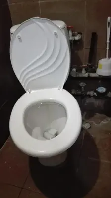 a white toilet with the seat up in a bathroom at Стаи на пъпа на Варна, входа на Морската градина in Varna City