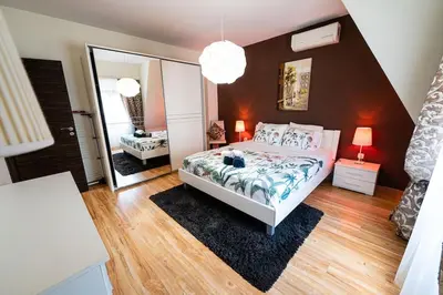 a bedroom with a bed and a large mirror at При Галя / Прекрасен апартамент в тих квартал in Varna City
