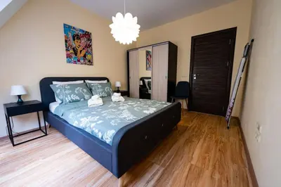 a bedroom with a bed and a chandelier at При Галя / Прекрасен апартамент в тих квартал in Varna City