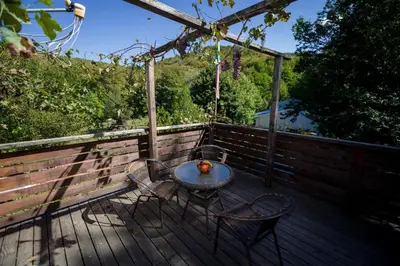 a table and two chairs on a wooden deck at Рибарник Forest Мagic in Topolitsa
