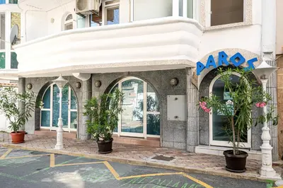 a building with potted plants in front of it at Family Hotel Paros 2 in Pomorie