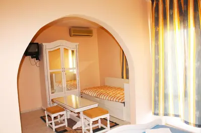 a small room with a bed and a mirror at Family Hotel Paros 2 in Pomorie