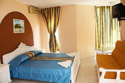 a bedroom with a blue bed and a window at Family Hotel Paros 2 in Pomorie