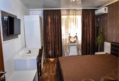 a bedroom with a bed and a television and a window at Dimitur Jekov Guest House in Obzor