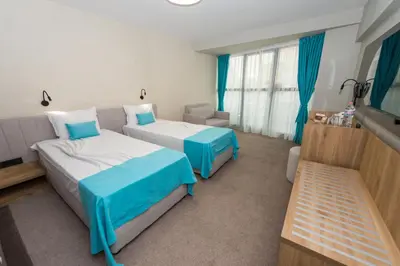 a hotel room with two beds and a couch at Grand Hotel Sunny Beach - All Inclusive in Sunny Beach