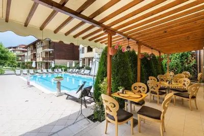 a patio with tables and chairs next to a pool at Liliya in Sveti Vlas