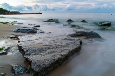 a group of rocks on a beach with the ocean at Liliya in Sveti Vlas