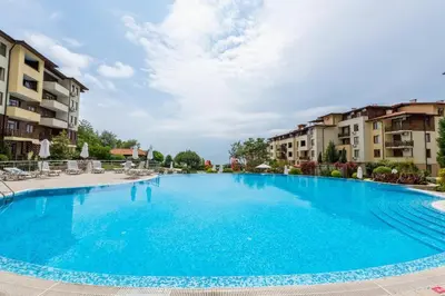 a large blue swimming pool in a apartment complex at Liliya in Sveti Vlas