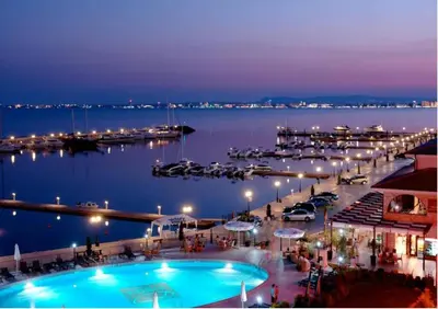 a view of a marina at night with a pool at Liliya in Sveti Vlas