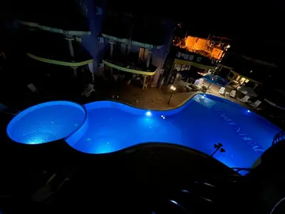 a large blue swimming pool at night at Camping Gradina Garden Beach b33 in Chernomorets