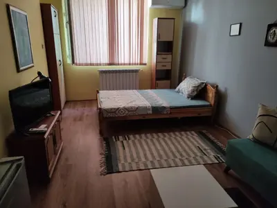 a small room with a bed and a television at Стая за гости на гр.Бургас in Burgas City