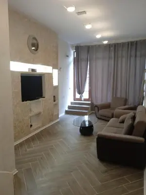 a living room with a couch and a flat screen tv at Апартаменти Стефанов in Varna City