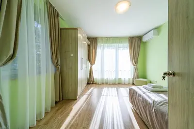 a bedroom with a bed and a large window at Sunny and Quiet 2bdr Central Apartment in Varna City
