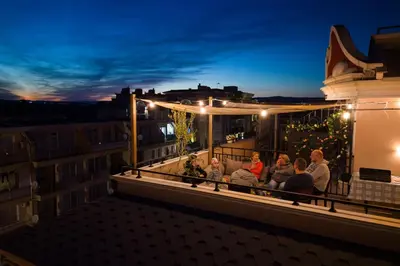 a group of people sitting on a balcony at night at Messembria Resort in Sunny Beach