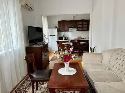 a living room with a couch and a table with flowers on it at Апартамент Опера. Стил и комфорт. Идеален център. in Varna City