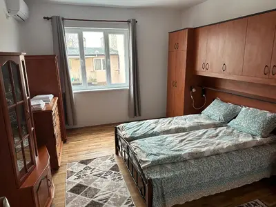 a bedroom with a bed with a wooden headboard and a window at Апартамент Опера. Стил и комфорт. Идеален център. in Varna City