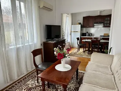a living room with a couch and a table with flowers on it at Апартамент Опера. Стил и комфорт. Идеален център. in Varna City