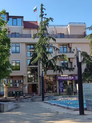 a building with a tree in front of it at Къща за гости КИТАНОВ in Pomorie
