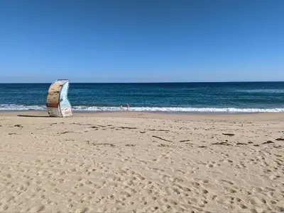 a boat sitting on the beach with the ocean in the background at Urlaub - Obzor Beach Resort A109 in Obzor
