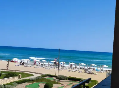 a beach with chairs and umbrellas and the ocean at Urlaub - Obzor Beach Resort A109 in Obzor