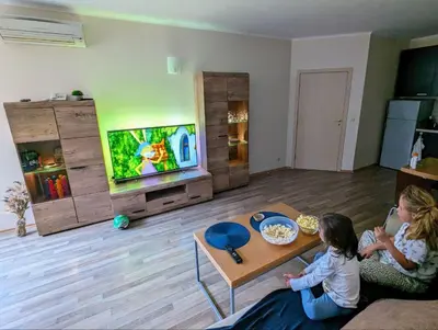 two girls sitting in a living room playing a video game at Urlaub - Obzor Beach Resort A109 in Obzor