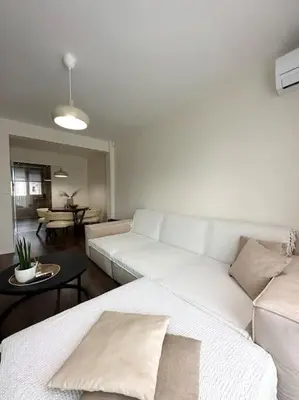 a living room with a white couch and a table at New luxury furnished apartment - beach, Varna center & fast Wi-FI in Varna City