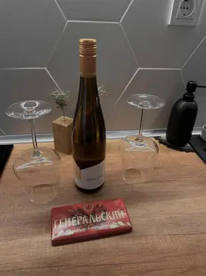a bottle of wine and two wine glasses on a table at New luxury furnished apartment - beach, Varna center & fast Wi-FI in Varna City