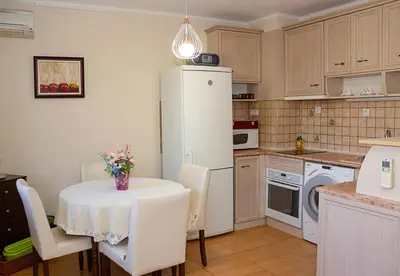 a kitchen with a table and a white refrigerator at Cozy 1BD Apartment with Free Parking in the Area by Flat Mаnager in Varna City