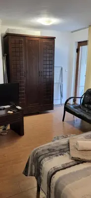 a bedroom with a bed and a table and a cabinet at Cozy apartment in the hart of the city in Varna City