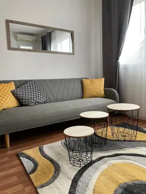 a living room with a couch and two tables at Sity Home in Burgas City