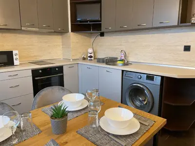 a kitchen with a table and a washing machine at Sity Home in Burgas City
