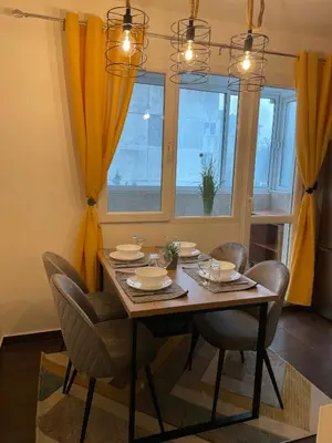 a dining room with a table and chairs and a window at Sity Home in Burgas City