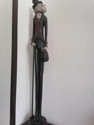 a statue of a man wearing a top hat and holding a purse at Оазис 1 във Варна in Varna City