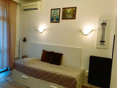 a bedroom with a bed with two pillows and a television at Оазис 2 във Варна in Varna City