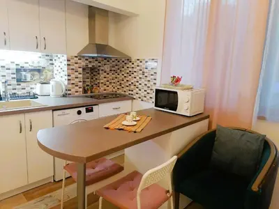 a small kitchen with a table and a microwave at Оазис 2 във Варна in Varna City