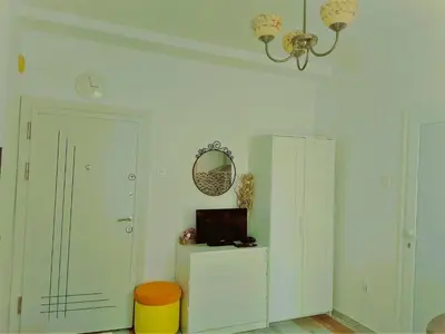 a room with a tv and a cabinet and a clock at Оазис 2 във Варна in Varna City
