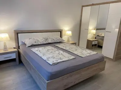 a bedroom with a bed with two lamps and a mirror at Sonne, Meer und mehr in Nesebar