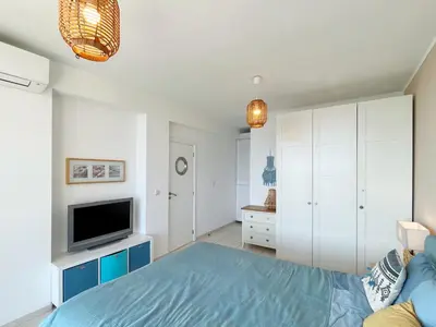 a bedroom with a blue bed and a tv at Dolce Vita Blue Boho, Premium Apartment with seaview in Sveti Vlas