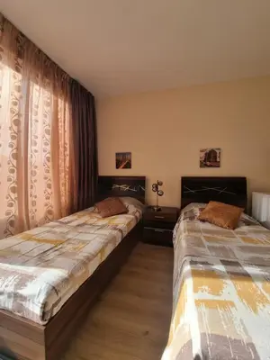 two beds sitting in a room with curtains at Deluxe Admiral Plaza in Sunny Beach
