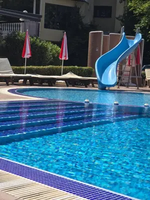 a blue plastic slide in a swimming pool at Deluxe Admiral Plaza in Sunny Beach