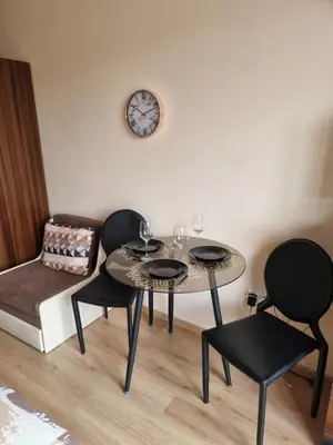 a dining room with two tables and chairs and a clock at Deluxe Admiral Plaza in Sunny Beach