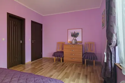 a bedroom with pink walls and a dresser and two chairs at Infinity View Shkorpilovci in Shkorpilovtsi
