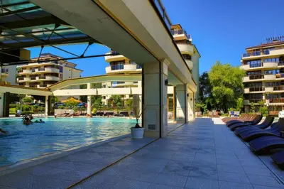 a swimming pool next to a building with buildings at Infinity View Shkorpilovci in Shkorpilovtsi