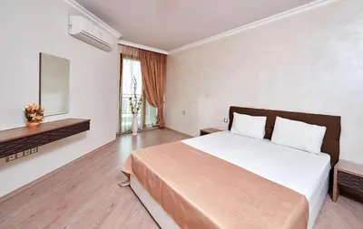 a bedroom with a large bed and a window at Boutique Rose Gardens Pomorie in Pomorie