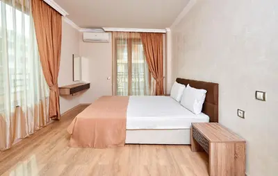 a bedroom with a bed and a large window at Boutique Rose Gardens Pomorie in Pomorie