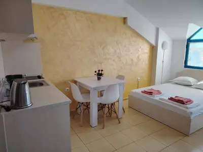 a small kitchen with a table and a bed in a room at Жасмин клуб in Sunny Beach
