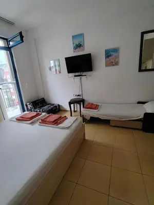 a room with two beds and a flat screen tv at Жасмин клуб in Sunny Beach