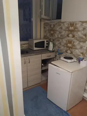 a small kitchen with a microwave and a refrigerator at Апартамент стоенчо хаджииванов,10 in Varna City