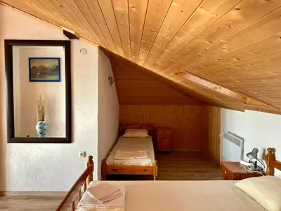 a bedroom with two beds and a wooden ceiling at Sozopol Old Town - Studio 5 Attic in Sozopol
